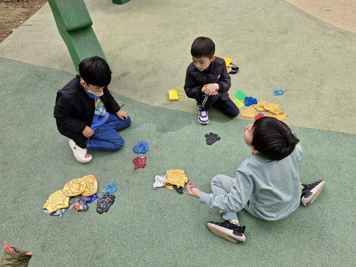 Chilren in Korea playing Ttakji with plastic toys